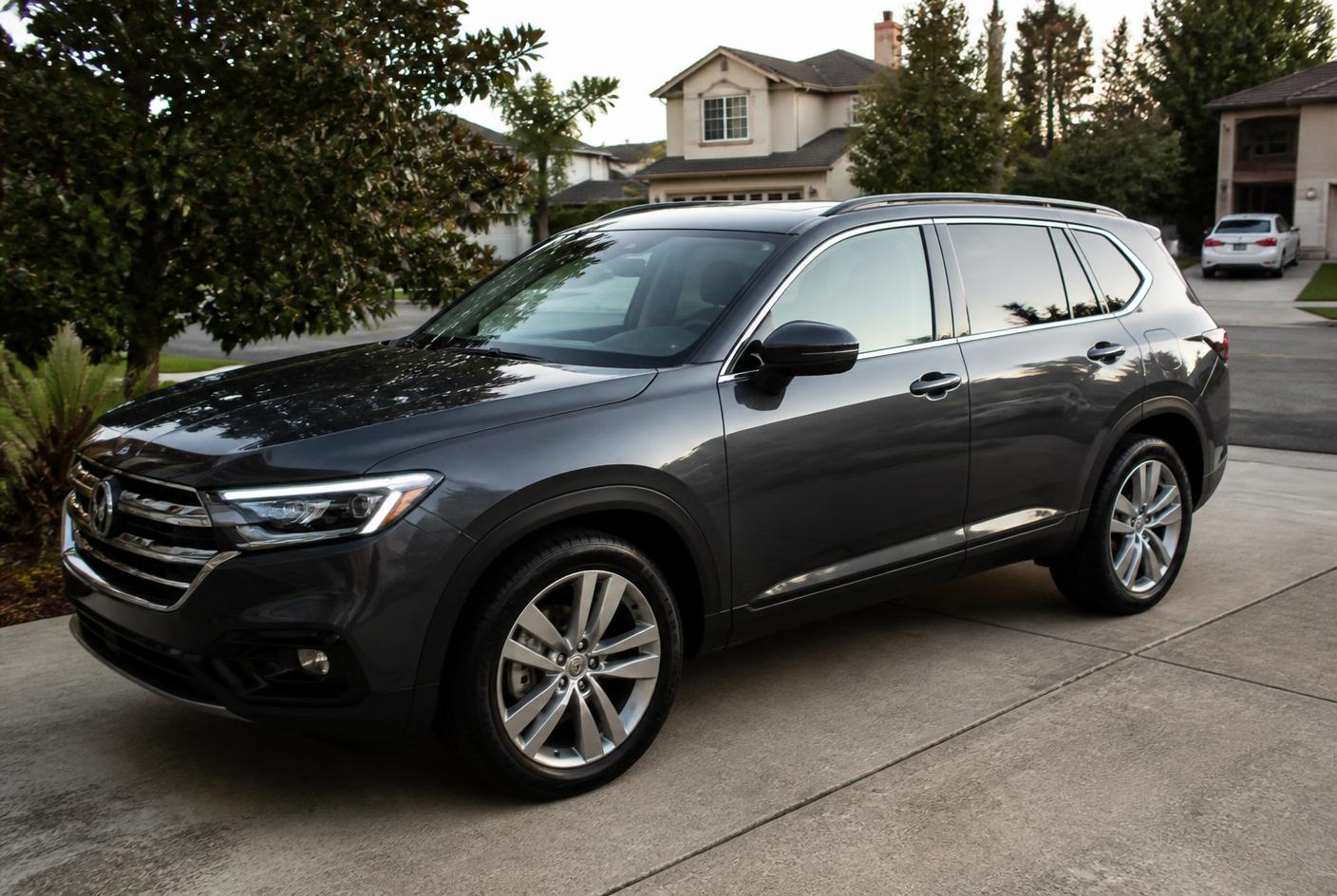 Freshly detailed dark gray SUV with glossy paint in a driveway